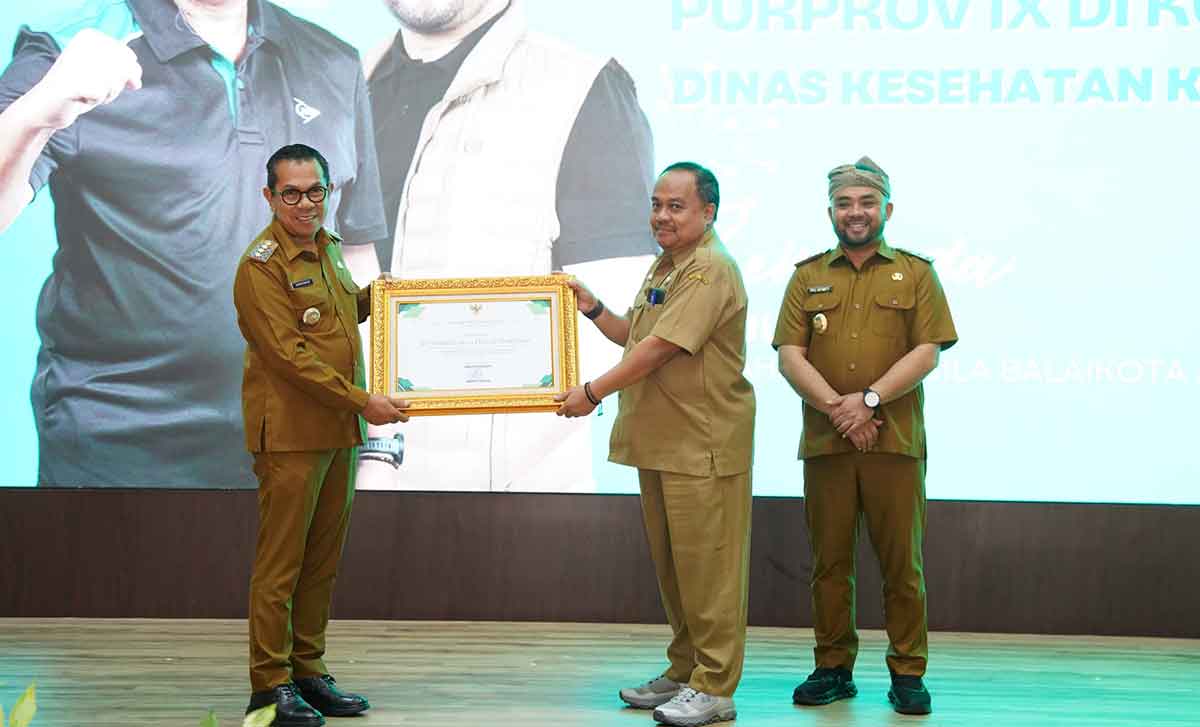 Wali Kota Batu saat menyerahkan piagam apresiasi kepada perwakilan tim kesehatan Porprov Jatim 2025.