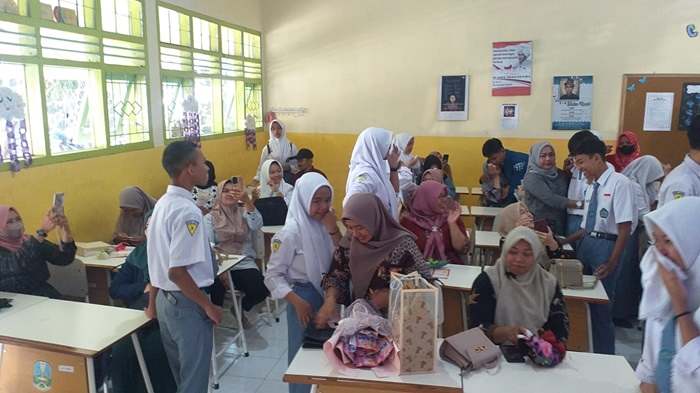 Para siswa dan wali murid SMAN 2 Kota Batu saling berpelukan dan berbagi bunga saat pembagian rapor.