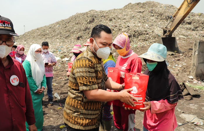 Bupati Gresik Fandi Akhmad Yani memberikan paket sembako kepada pemulung dan petugas kebersihan. foto: SYUHUD/ BANGSAONLINE