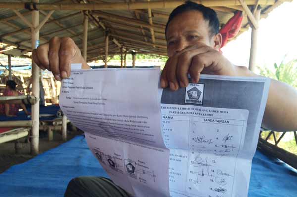 TUNJUKKAN: Ketua PAC Partai Gerindra Kecamatan Pesantren, Hartono, saat menunjukkan surat mosi tidak percaya kepada Ketua DPC mereka. foto: arif kurniawan/BANGSAONLINE