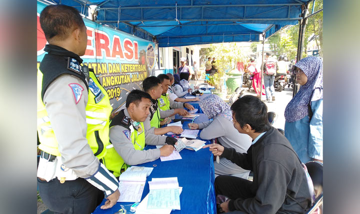Para pelanggar saat menunggu proses penilangan dari pihak Satlantas Polres Malang Kota usai terjaring operasi patuh Semeru di Terminal Landungsari Malang, Rabu (11/09). foto: IWAN IRAWAN/ BANGSAONLINE