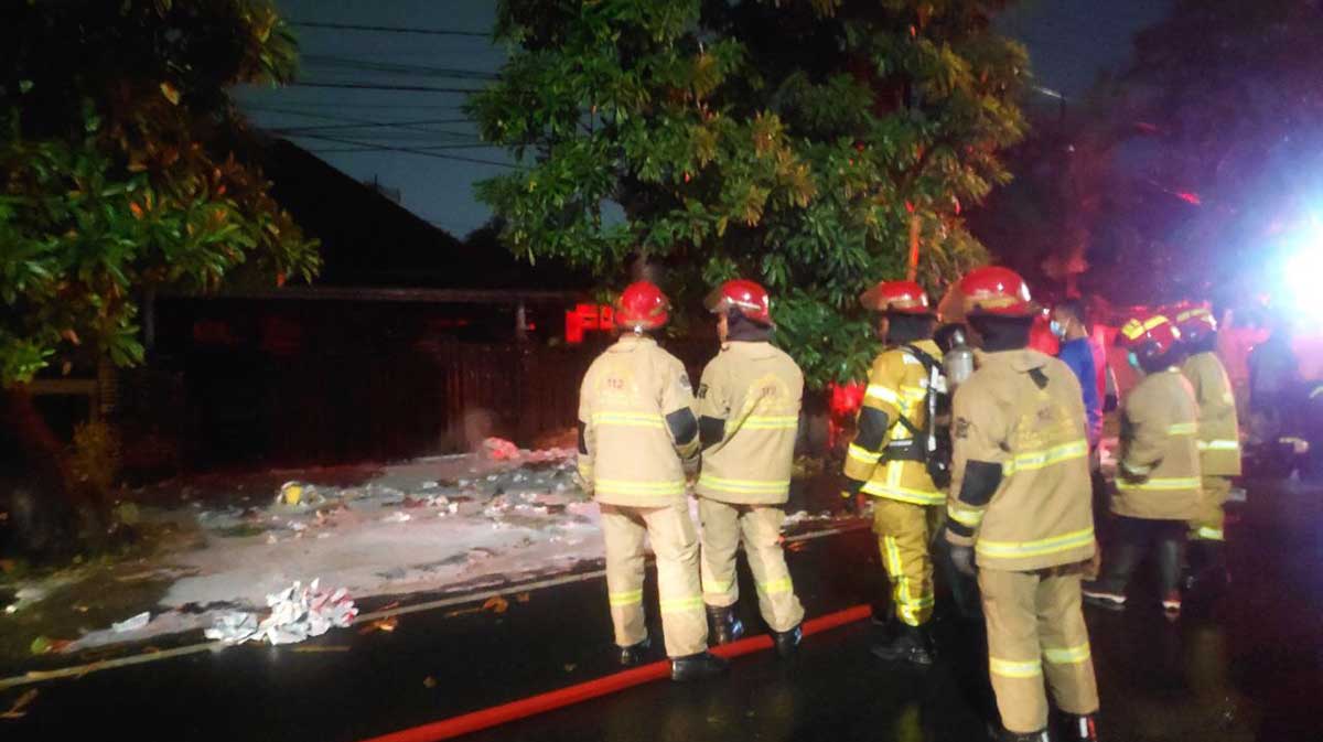 Petugas saat memadamkan api yang membakar muatan jasa kirim di dekat Markas Brimob, Jalan Gresikan, Surabaya.