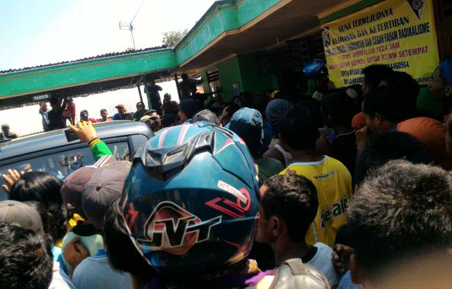 Warga yang geram masih mengerumuni pelaku saat petugas hendak menggelandangnya ke Mapolres Tuban untuk diperiksa. foto: suwandi/ BANGSAONLINE