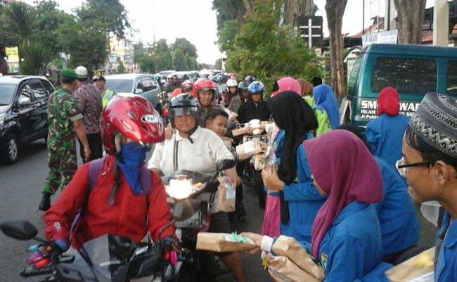 Siswa-siswi SMP Iswada Sidoarjo membagikan takjil buka puasa gratis, di Jalan Pahlawan, Sidoarjo, Kamis (9/6) petang. foto: istimewa