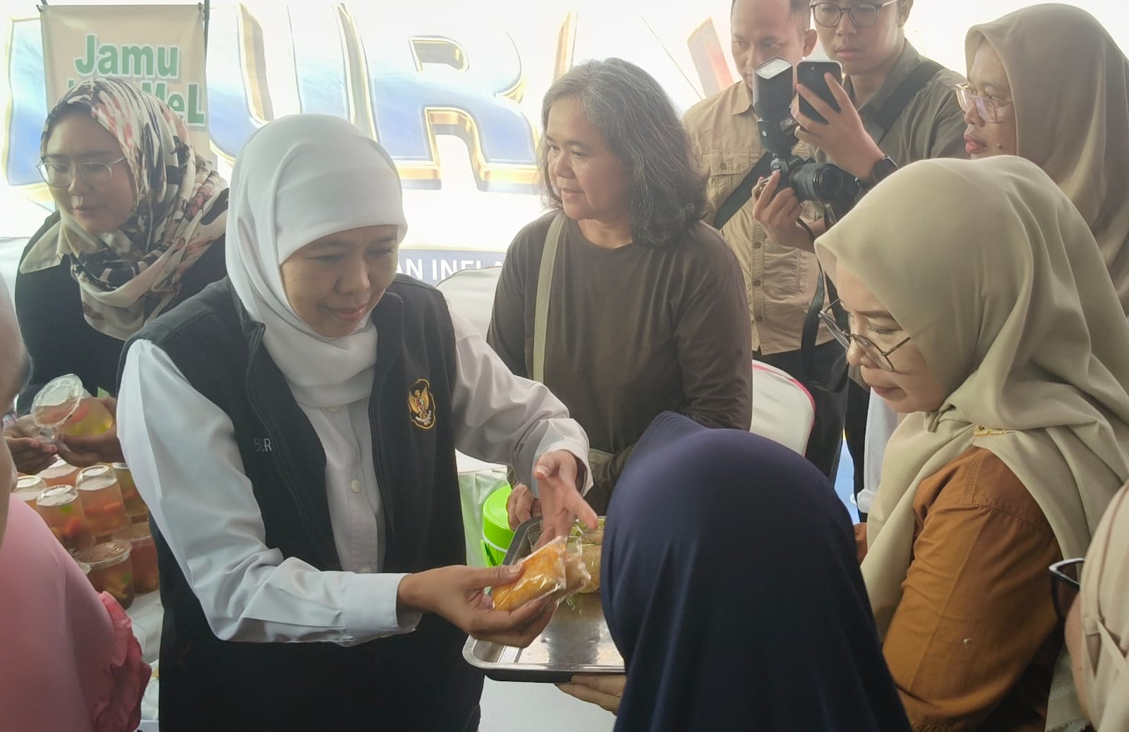 Gubernur Khofifah saat membagikan snack dan minuman secara gratis kepada warga. Foto: Muji Harjita/BANGSAONLINE.com 