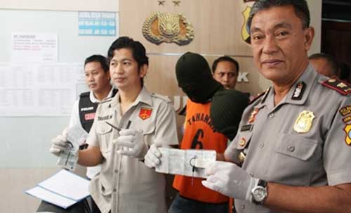 Kasat Reskrim (dua dari kiri), Kapolsek dan Kanit Reskrim bersama tersangka. (foto: rusmiyanto/BANGSAONLINE)