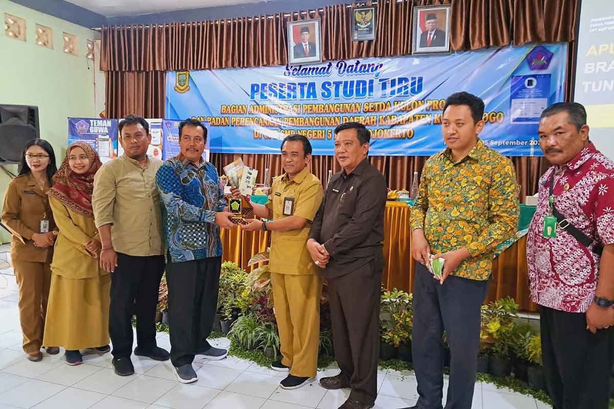 Kepala SMPN 5, Nono Purnomo, didampingi Kepala Disdikbud Kota Mojokerto, Amin Wachid, ketika menerima cendera mata dari kunjungan Pemkab Kulonprogo.