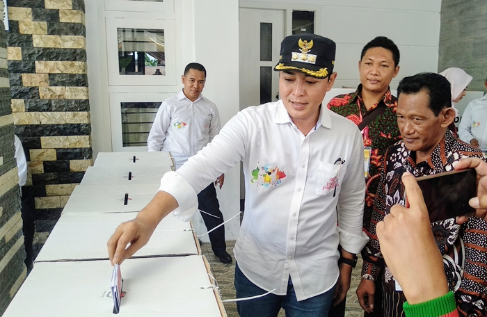 Bupati Pamekasan Baddrut Tamam saat memasukkan surat suara ke dalam salah satu kotak suara.