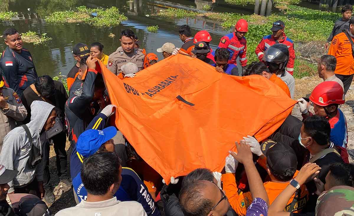 Petugas saat mengevakuasi jenazah pria yang bunuh diri di Surabaya.