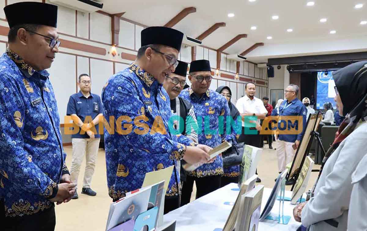 Wakil Bupati Gresik ketika membaca salah satu koleksi buku saat peluncuran Rubadira. Foto: SYUHUD/BANGSAONLINE