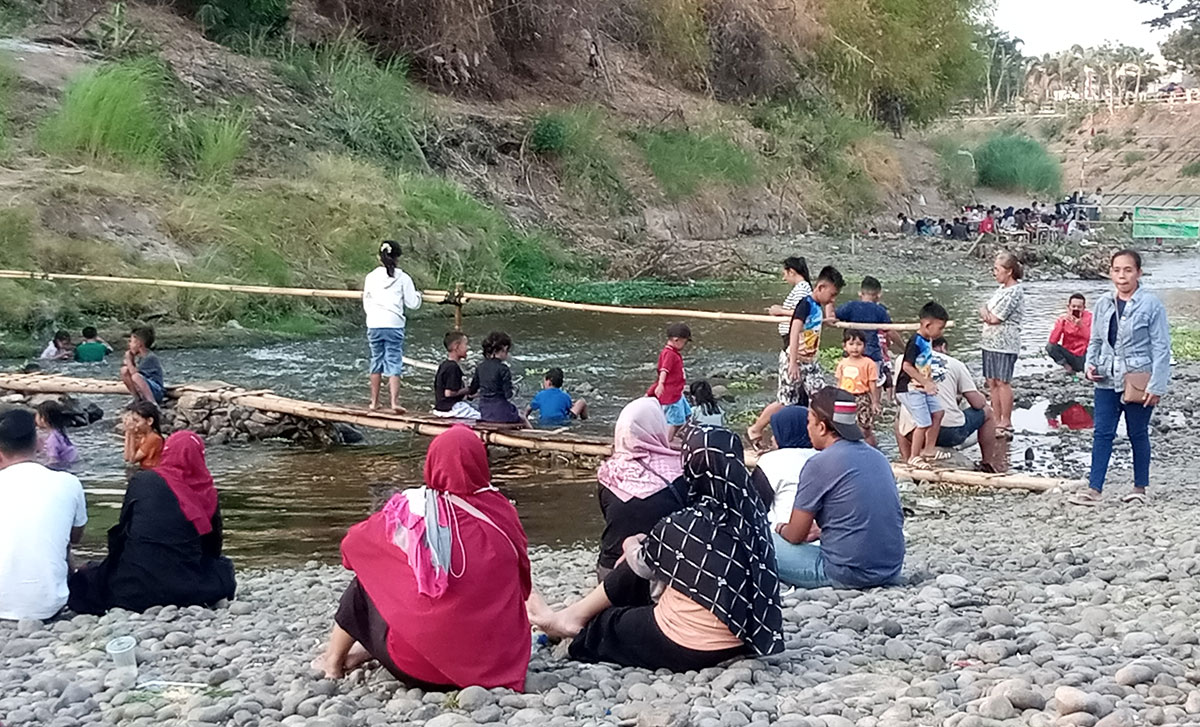 Pemandangan di bantaran Sungai Madiun yang tiap sore hari dipenuhi warga. Foto: HENDRO SUHARTONO/ BANGSAONLINE 