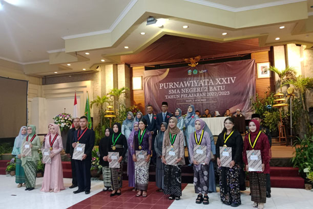 Kepala SMA Negeri 2 Batu dan para wakil kepala sekolah foto bersama dengan lulusan terbaik.