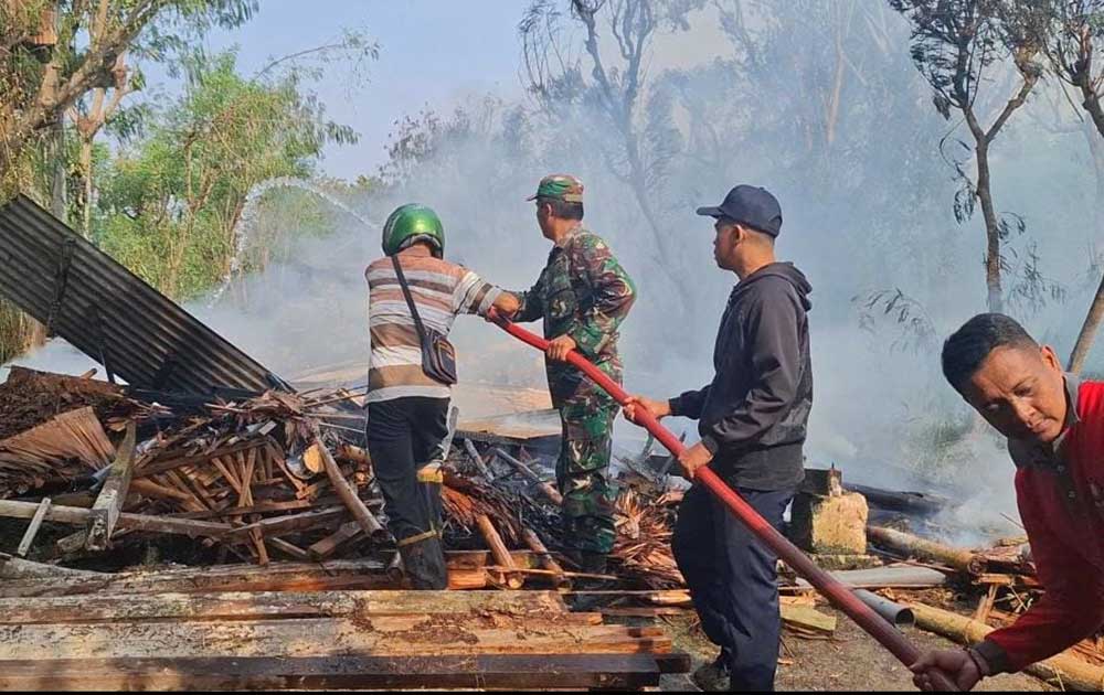 Petugas Damkar Bangkalan saat melakukan pembasahan terhadap kandang ayam yang terbakar.