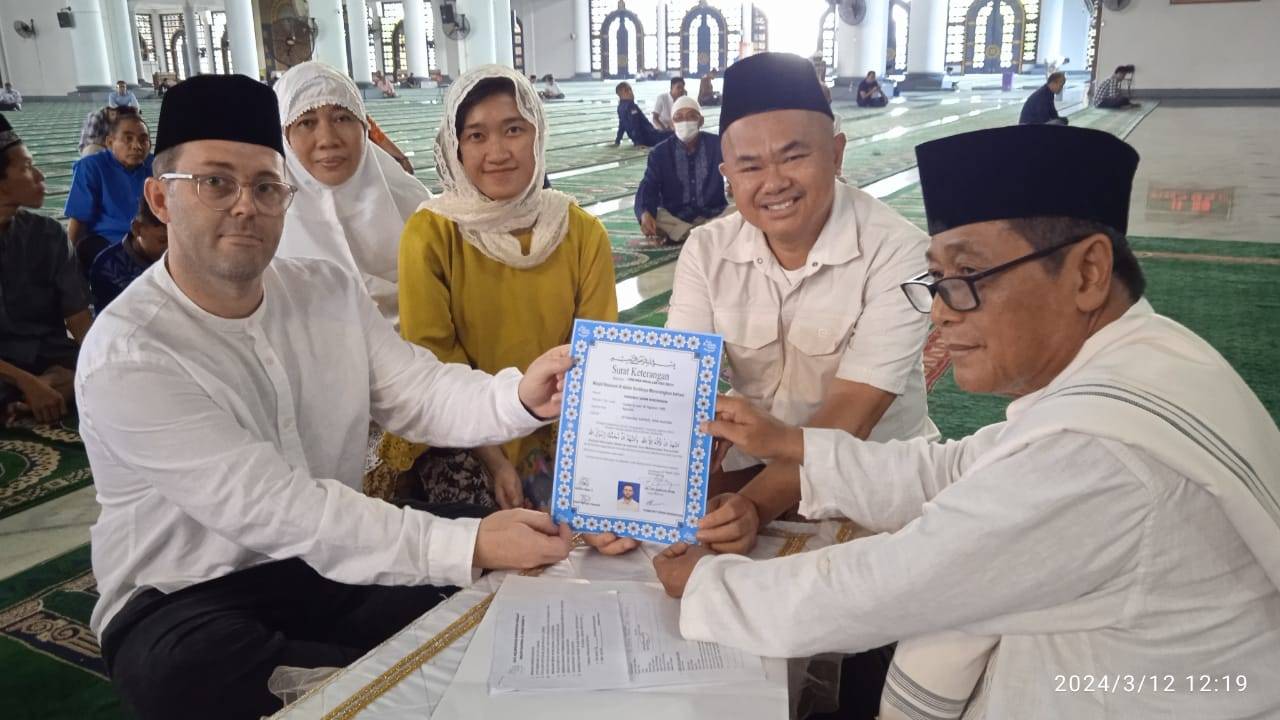 Timothy John Rogerson (kiri) memegang surat pernyataan masuk Islam yang baru ditandatangani bersama Dr KH M Sujak, M.Ag (kanan) di Masjid Al-Akbar Surabaya, Selasa (12/3/2024). Foto: masjidalakbar.or.id 