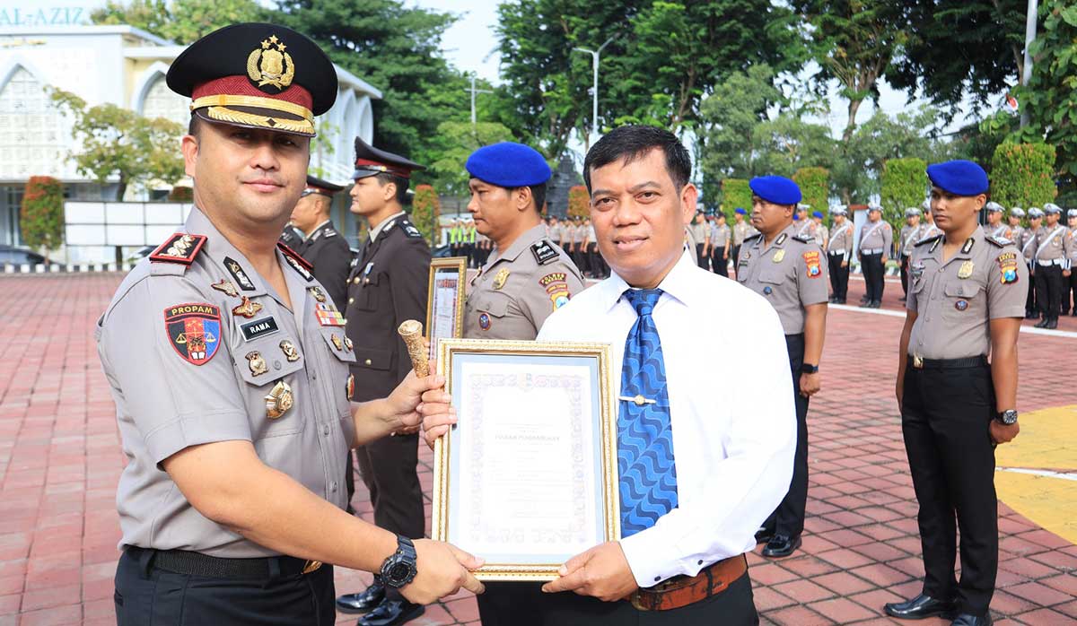 Kapolres Gresik, AKBP Ramadhan Nasution (kiri), ketika menyerahkan penghargaan kepada personel berprestasi. Foto: Ist