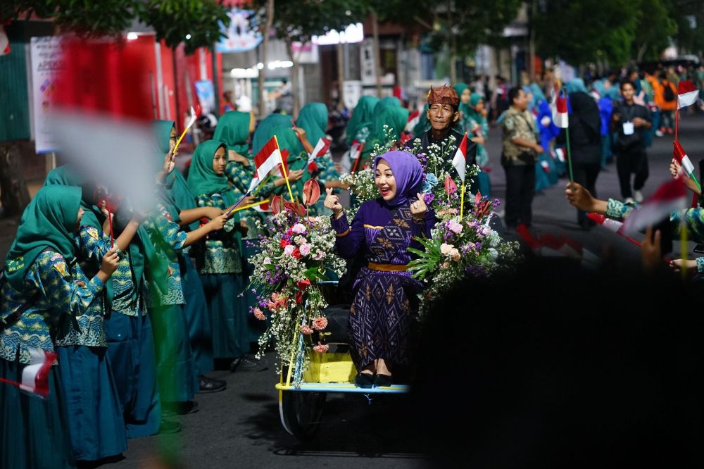 Salah satu delegasi saat naik becak disambut oleh para pelajar dan warga. (Ist). 