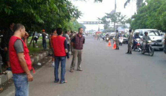 BERJAGA: Sejumlah warga dan Satpol PP tampak berjaga di pintu gerbang Perum TPI Sidoarjo, Minggu (20/3). foto: musta’in/ BANGSAONLINE