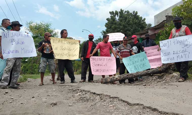 Puluhan warga Kecamatan Sampung menggelar unjuk rasa memprotes akses jalan yang rusak parah.