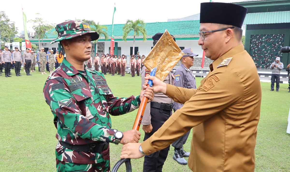 Wakil Bupati Gresik (kanan) saat menyerahkan sekop kepada personel TNI saat pembukaan TMMD ke-124 di Desa Banter, Kecamatan Benjeng. Foto: Ist