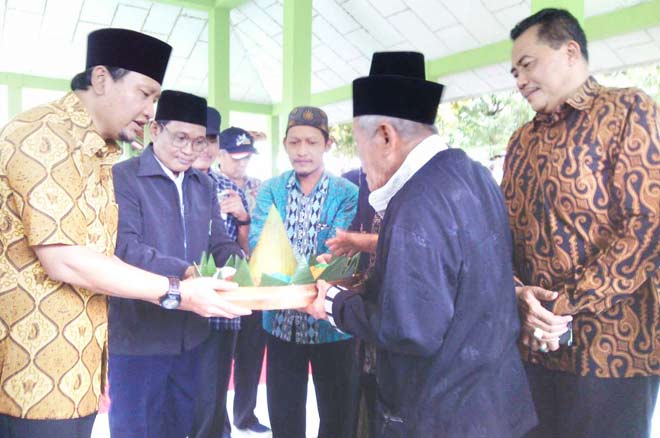 Bupati Pasuruan HM Irsyad Yusuf menyerahkan tumpeng kepada Mbah Kholiq, Juru Kunci Ranu.