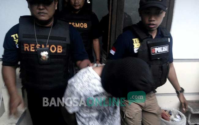 Petugas Satreskrim Polres Kediri saat mengamankan pelaku dari rumahnya. foto: arif kurniawan/ BANGSAONLINE