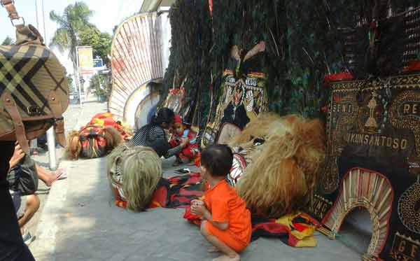 Nampak beberapa warga sedang memfotokan anaknya bersama reog yang dijemur. (foto: dendi martoni/BANGSAONLINE)