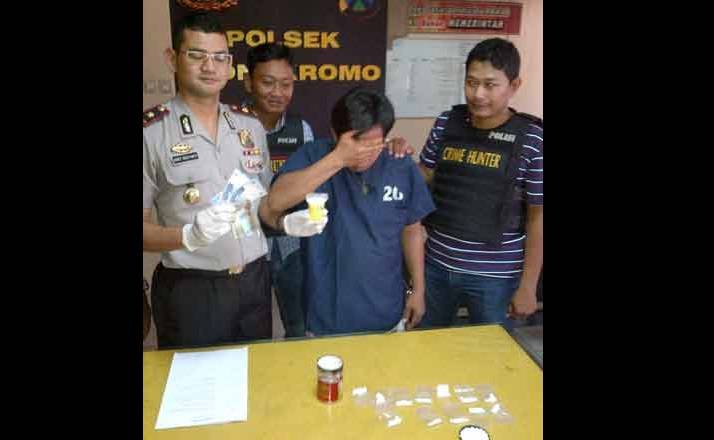 Pelaku beserta barang bukti pil koplo yang dipamerkan. (foto: rusmiyanto/BANGSAONLINE)