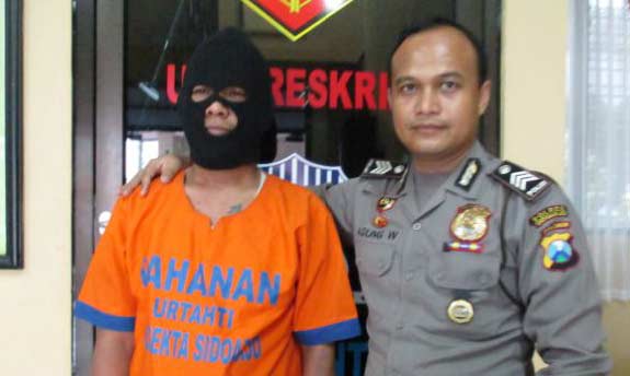 Tersangka didampingi petugas dari Mapolsek Sidoarjo Kota. foto: catur 