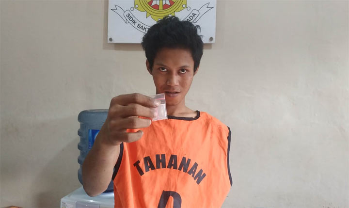 Tersangka Adi Yuda Pamungkas (22) menunjukkan barang bukti sabu yang baru saja dibelinya.