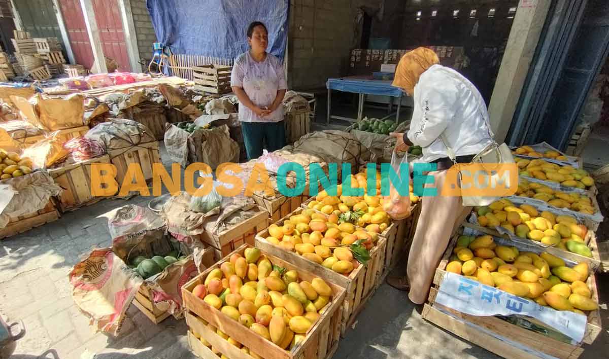 Ika, salah satu pedagang di Pasar Grosir Buah Banyakan saat melayani konsumen. Foto: MUJI HARJITA/BANGSAONLINE