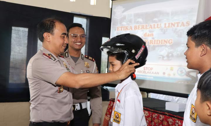 Kapolres Ponorogo AKBP Radiant saat memakaikan helm siswa SMP Terpadu.