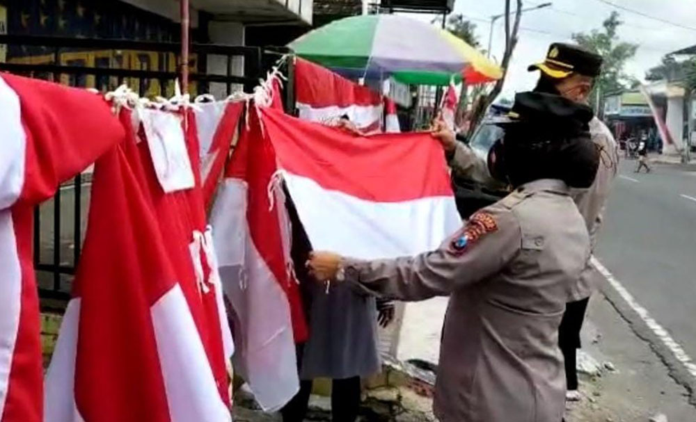 Kapolres Blitar Kota AKBP Yudhi Hery Setyawan saat memborong bendera merah putih yang dijual salah satu pedagang.