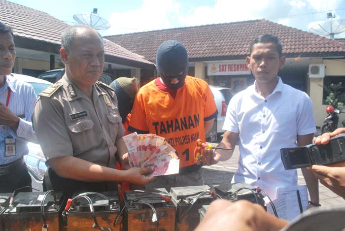 Pasutri saat di kantor Polres Ngawi bersama barang bukti berupa baterai dan sejumlah uang.