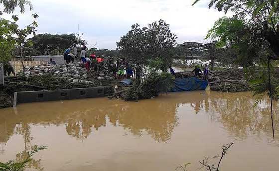 Warga saat gotong royong menutup tanggul dengan peralatan seadanya. foto: eko sudjarwo/ detik.com
