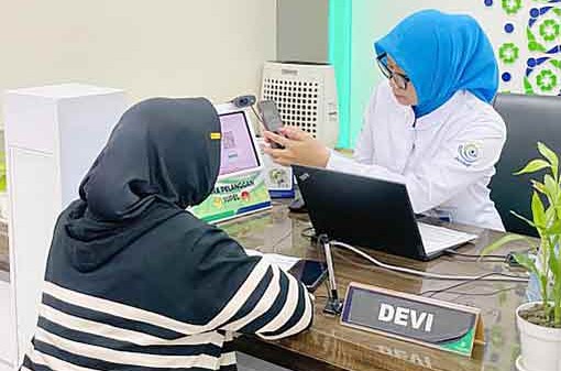 Petugas BPJS Kesehatan saat membantu peserta JKN mengecek status kepesertaan.