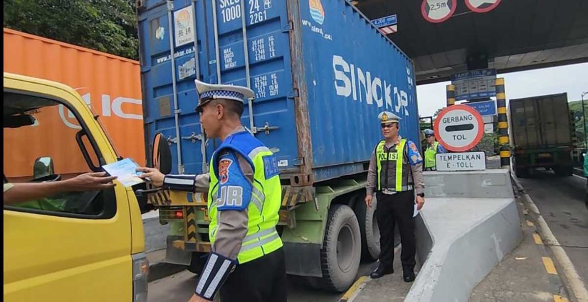 Petugas saat memberi flyer berisi imbauan penggunaan lajur kiri bagi kendaraan truk dan bus di tol.