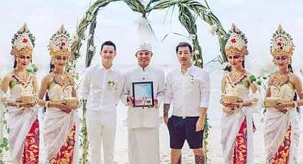 Dua “mempelai” gay (pakai baju putih no 3 dari kiri, satunya lagi pakai celana pendek)  diapit empat wanita cantik dengan pakaian adat Bali. foto: faceboook
