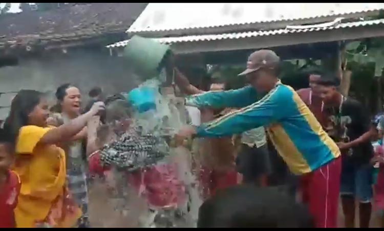 Mukadar saat dimandikan kembang dan ditaburi tepung oleh para tetangganya saat pulang dari karantina.