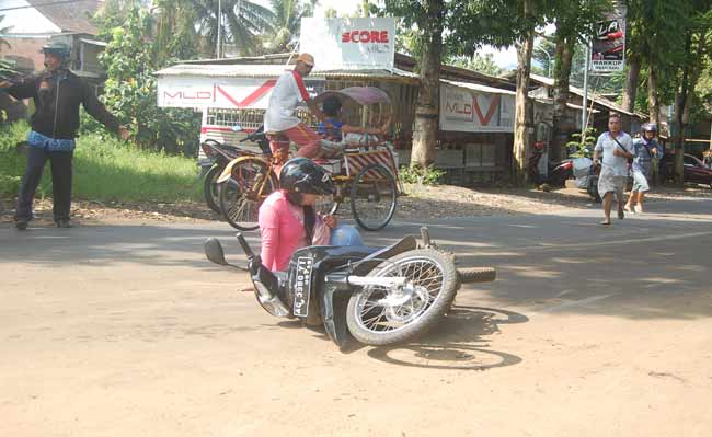 Salah satu wanita yang terjatuh saat melintas di tikungan barat Jembatan Jagalan, Ngantru, Trenggalek. foto: herman/ BANGSAONLINE