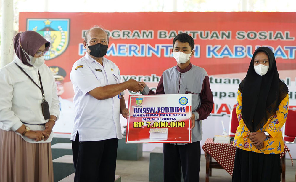 Plt Kepala Dispendik Kabupaten Kediri Mokhamat Muhsin saat menyerahkan secara simbolis beasiswa GNOTA kepada salah satu penerima. Foto: Ist.