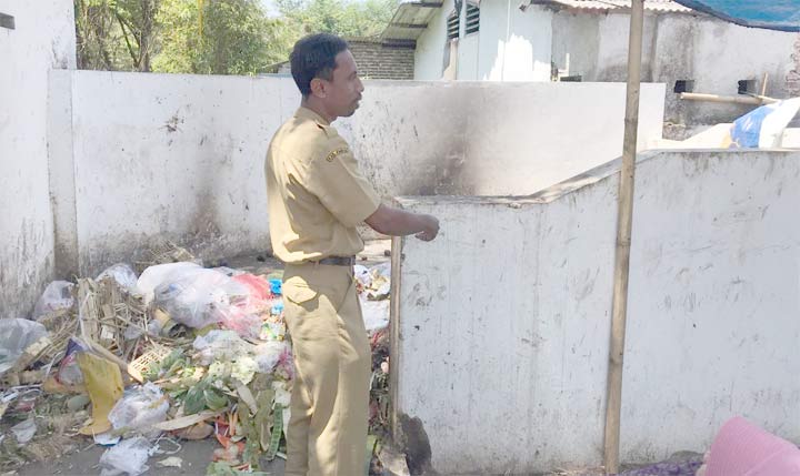 Plt Kepala SDN Jember Lor 5 Jember Poncodriyo saat menunjukkan lokasi pembuangan sampah pasar yang berdempetan dengan ruang kelas.