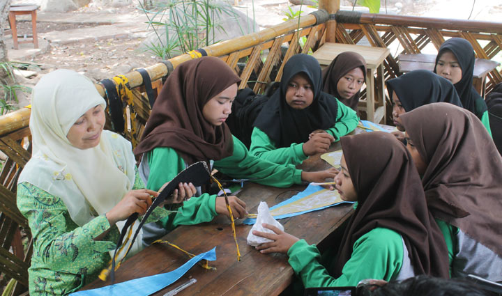 Siti Nur Imamah saat memberikan edukasi kepada pelajar cara membuat udeng khas Nganjuk. foto: BAMBANG/ BANGSAONLINE