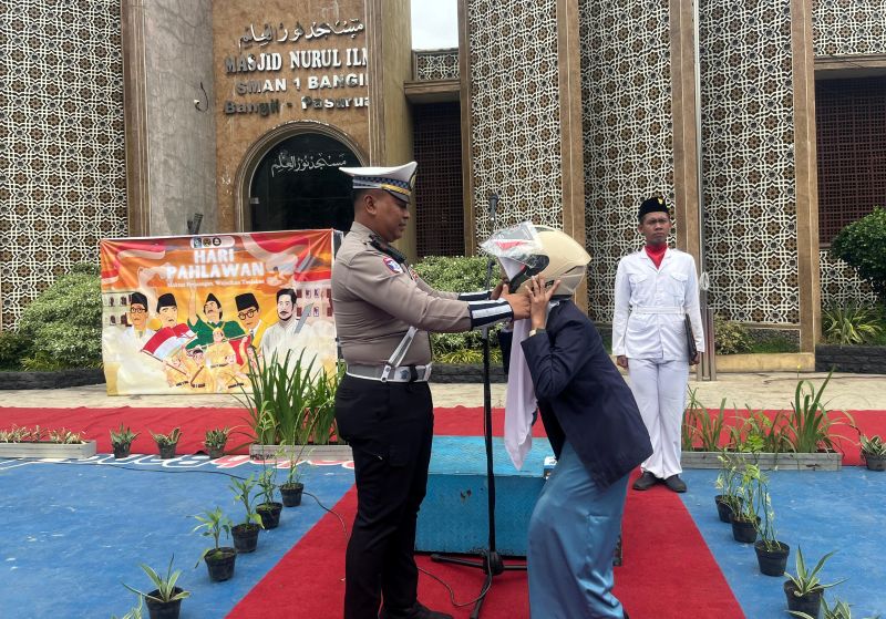 Kaur Min Ops Satlantas Polres Pasuruan saat membagikan helm gratis