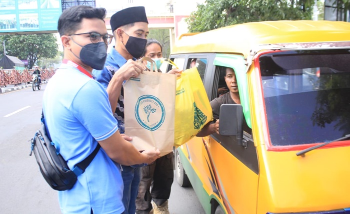 PEDULI: Ketua PWI Sidoarjo Abdul Rouf dan perwakilan Alfamart menyerahkan sembako kepada para sopir angkot, Jumat (22/4/2022). foto: istimewa