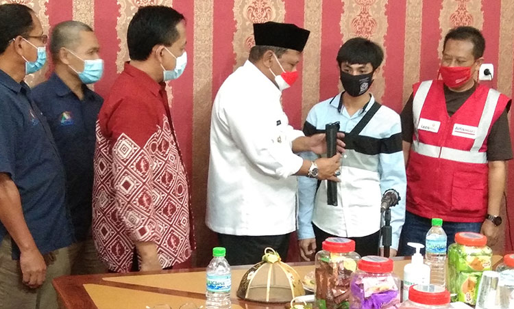 Plt Bupati Nganjuk, Marhaen Jumadi, saat menyerahkan secara simbolis tongkat dan sembako kepada penyandang tunanetra. Foto: BAMBANG/ BANGSAONLINE