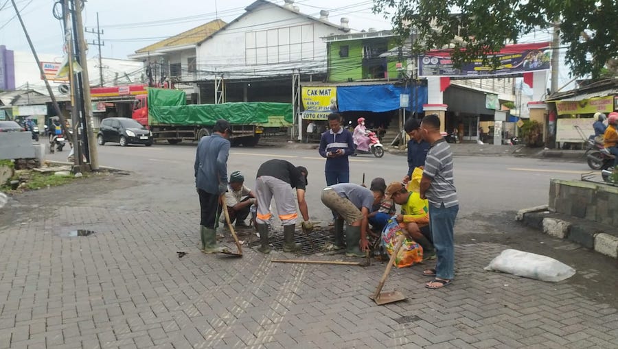 Satgas DCKPKP Gresik membersihkan saluran air di kawasan GKB. Foto: Ist.