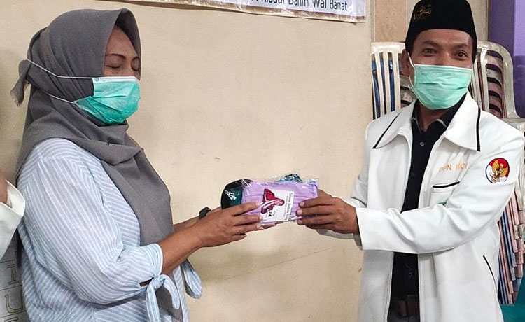 Ketua Pembina BM 99, Didik saat menyerahkan masker kepada warga Kota Pasuruan. (foto: ist)