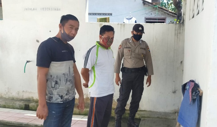 Pelaku sedang diapit petugas Polsek Padas, Ngawi.