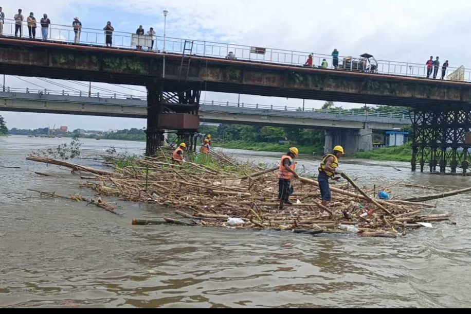 Petugas Gabungan saat membersihkan sampah yang nyangkut di pilar Jembatan Brantas Lama. (Ist). 
