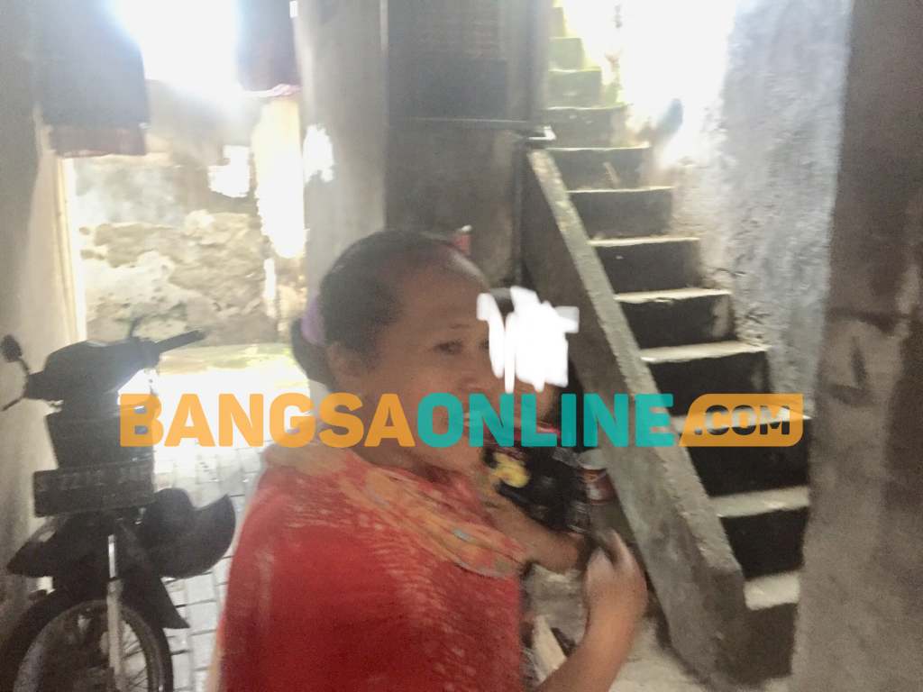 Salah seorang warga yang menujukkan tangga menuju kamar kos pelapor. FOTO: Rusmiyanto/BANGSAONLINE